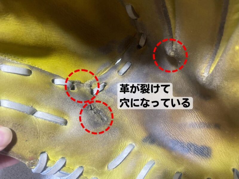 捕球面の革が裂けて穴になっているグローブの写真